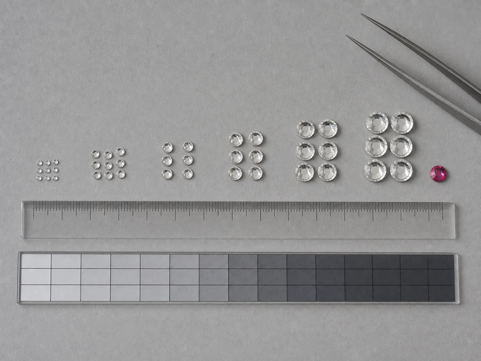 Rhinestones arranged by size above a metric ruler
